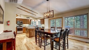 A spacious kitchen with wooden cabinets, a large island, and a dining area with wooden chairs.