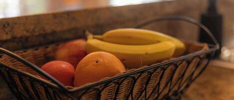 A basket containing fruits on a kitchen counter.