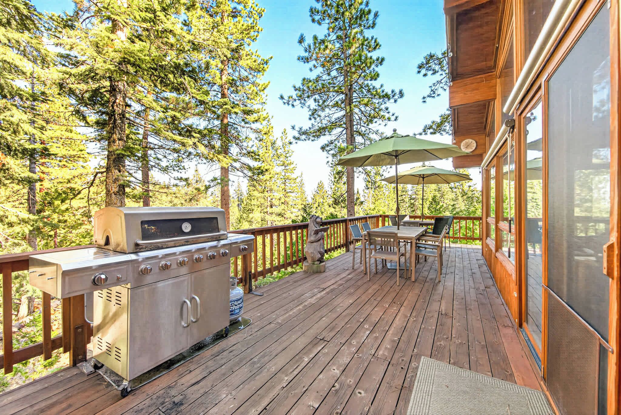 A wooden deck with a grill, outdoor table, chairs, and a statue.