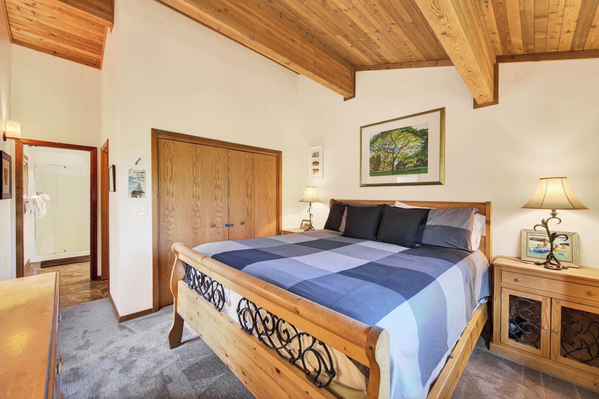 Ein Schlafzimmer mit einem hölzernen Bett, einem Schrank aus Holz, einem Nachttisch aus Holz und einem gerahmten Bild an der Wand.