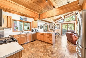 Una cocina amplia con armarios de madera, una isla grande y vistas al exterior.