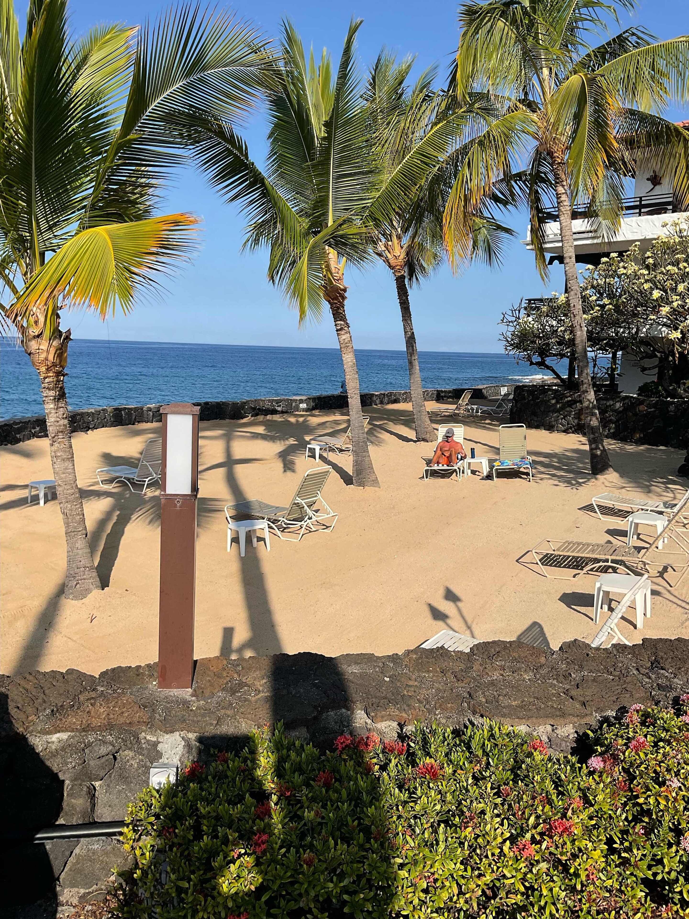 Une plage avec des chaises longues et un mur de pierre.