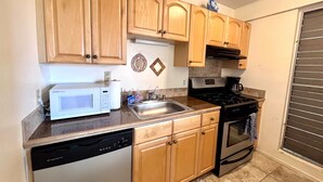 A kitchen with wooden cabinets, a microwave, a dishwasher, a sink, and a stove.