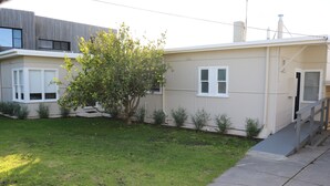 A residential building with a front yard, a tree, and a staircase leading to the entrance. - Sea Forever (Apollo Bay)