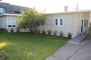 A residential building with a front yard, a tree, and a staircase leading to the entrance. - Sea Forever (Apollo Bay)