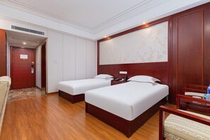 A hotel room with two single beds, a wooden headboard, a desk with a chair, and a large window with a floral pattern. - Greentree Inn Nantong Haimen Sanchang North Wangjiang Road Business Hotel (Nantong)
