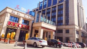 A building with a spa and a hotel. There are cars parked in front. - Greentree Inn Nantong Haimen Sanchang North Wangjiang Road Business Hotel (Nantong)