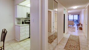 A spacious living area with a kitchen, a dining area, and a view of the outdoors. - St Pete Beach Yacht and Tennis Club 90 Day Rental Gated With Pool (St. Pete Beach)