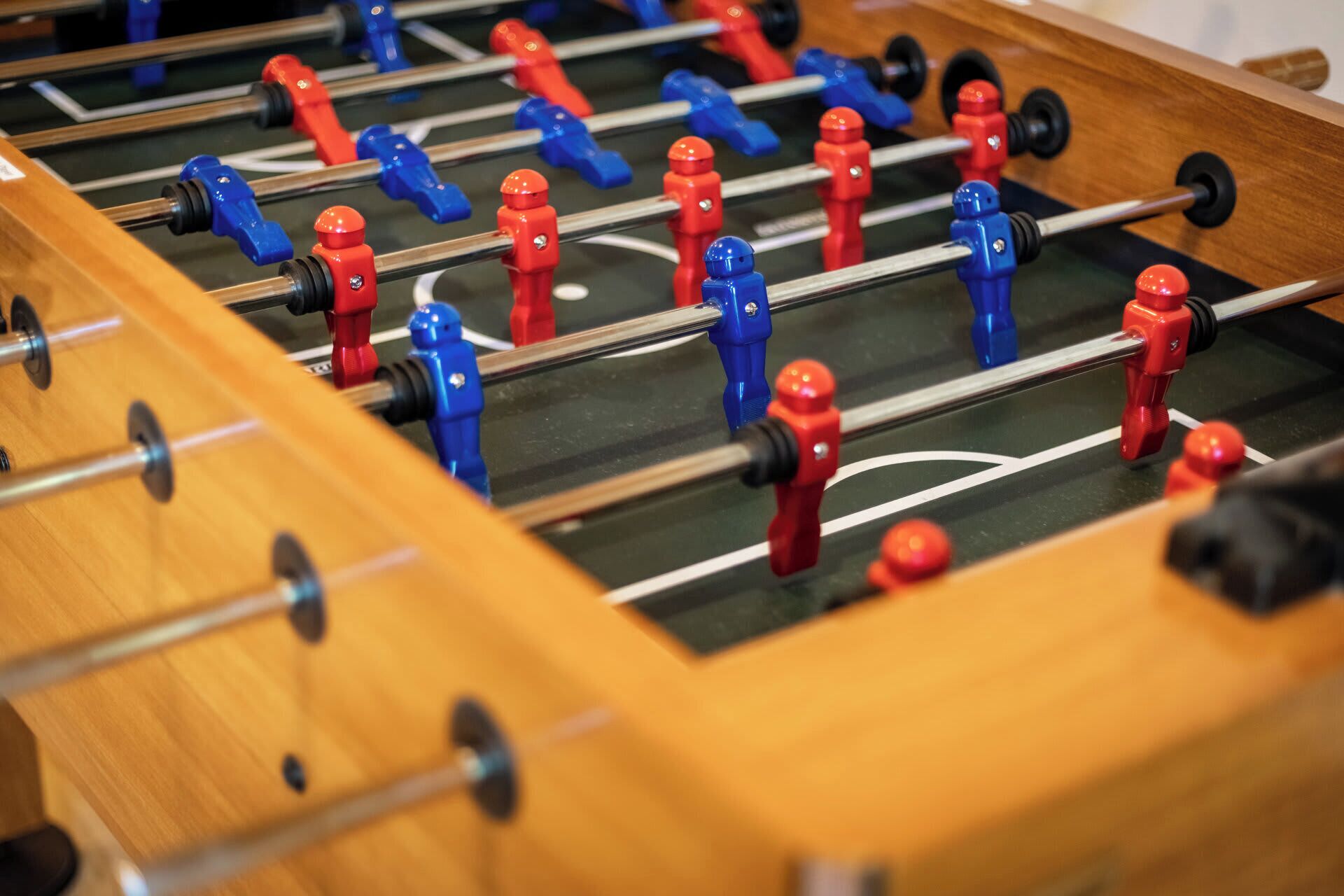 A close-up of a foosball table with red and blue players.