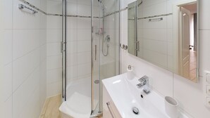 A modern bathroom with a glass-enclosed shower, a white sink with a mirror, and a toilet. - Studio Apartment , 33m2 (Bad Homburg vor der Höhe)
