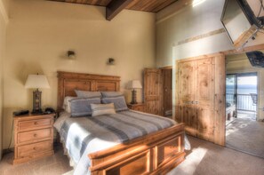 A bedroom with a wooden bed, two bedside tables with lamps, a wooden wardrobe, and a large mirror. - Brockway Springs Lodge Steps to Lake Access! (Kings Beach)