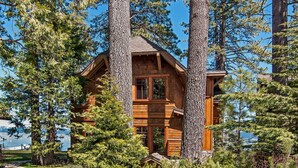 A wooden cabin surrounded by tall trees, with a clear view of the surrounding landscape. - West Lake Serenity 180 Degree Lake Views (Homewood)