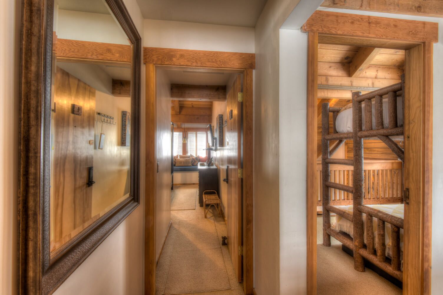 Un couloir étroit aux murs en bois, avec une échelle en bois menant à une chambre à coucher située en mezzanine.
