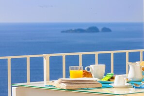 Una mesa de desayuno con vista al mar y a las islas.