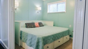Une chambre à coucher avec un lit, des lampes de chevet, une fenêtre et une porte.