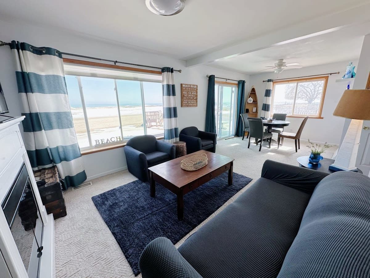 A living room with a sofa, armchairs, a coffee table, and a dining area with a table and chairs.