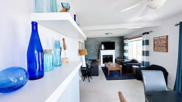 A modern living room with a fireplace, seating area, and a view of the outdoors.