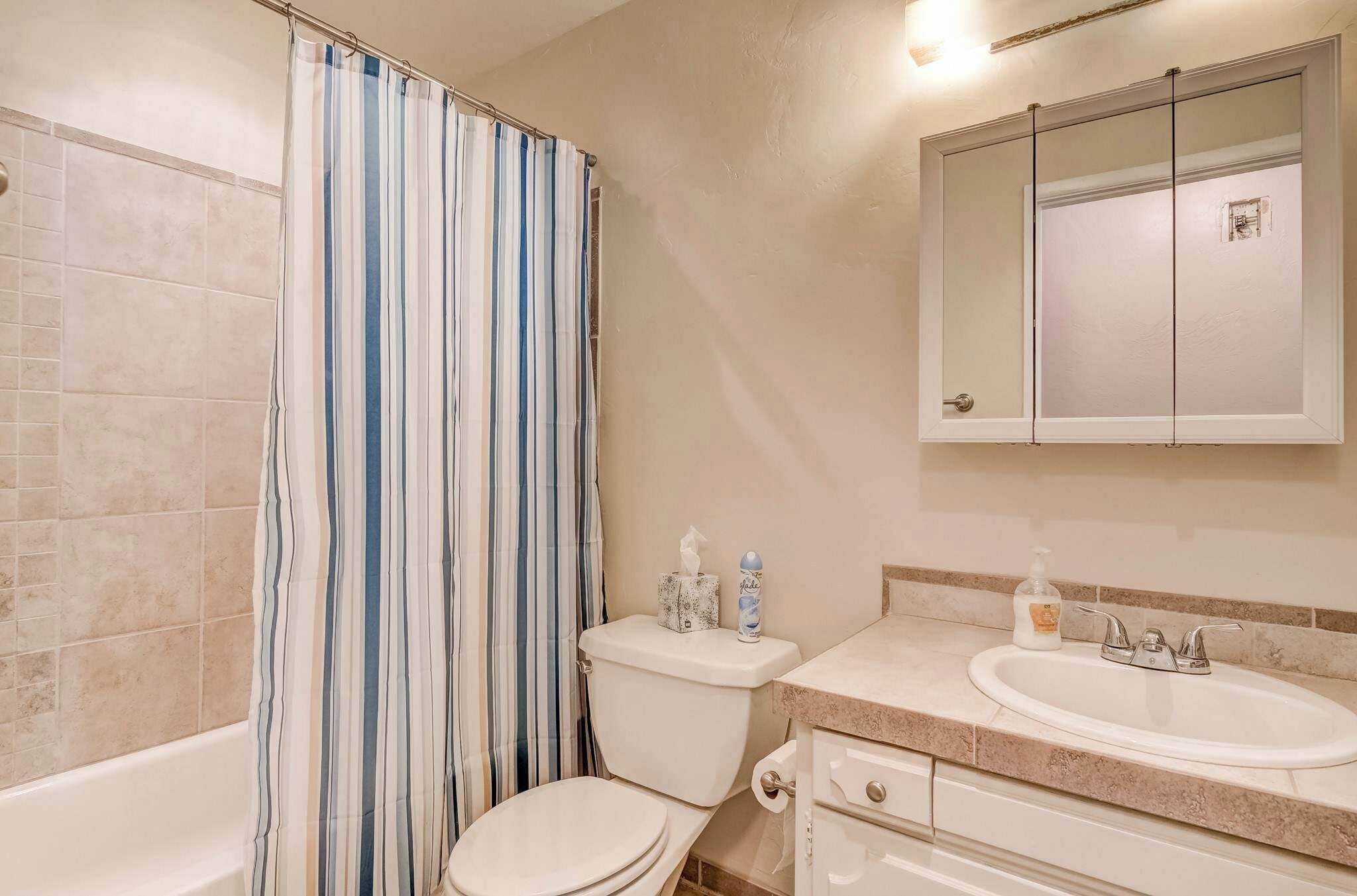 A bathroom with a bathtub, toilet, and sink.