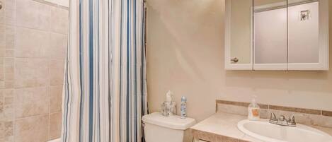 A bathroom with a bathtub, toilet, and sink.