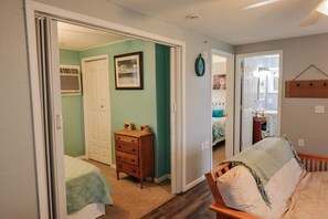 Un dormitorio con cama, cómoda y puerta que da a otra habitación.
