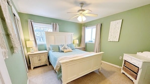 A bedroom with a bed, nightstands, a dresser, and a ceiling fan. - Beachfront cottage on Lake Huron (Oscoda)