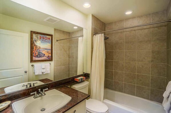Un baño con lavamanos, inodoro y ducha.