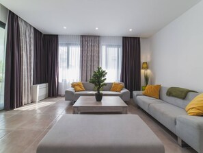 Una sala de estar moderna con un sofá, una mesa de centro y una planta en maceta.