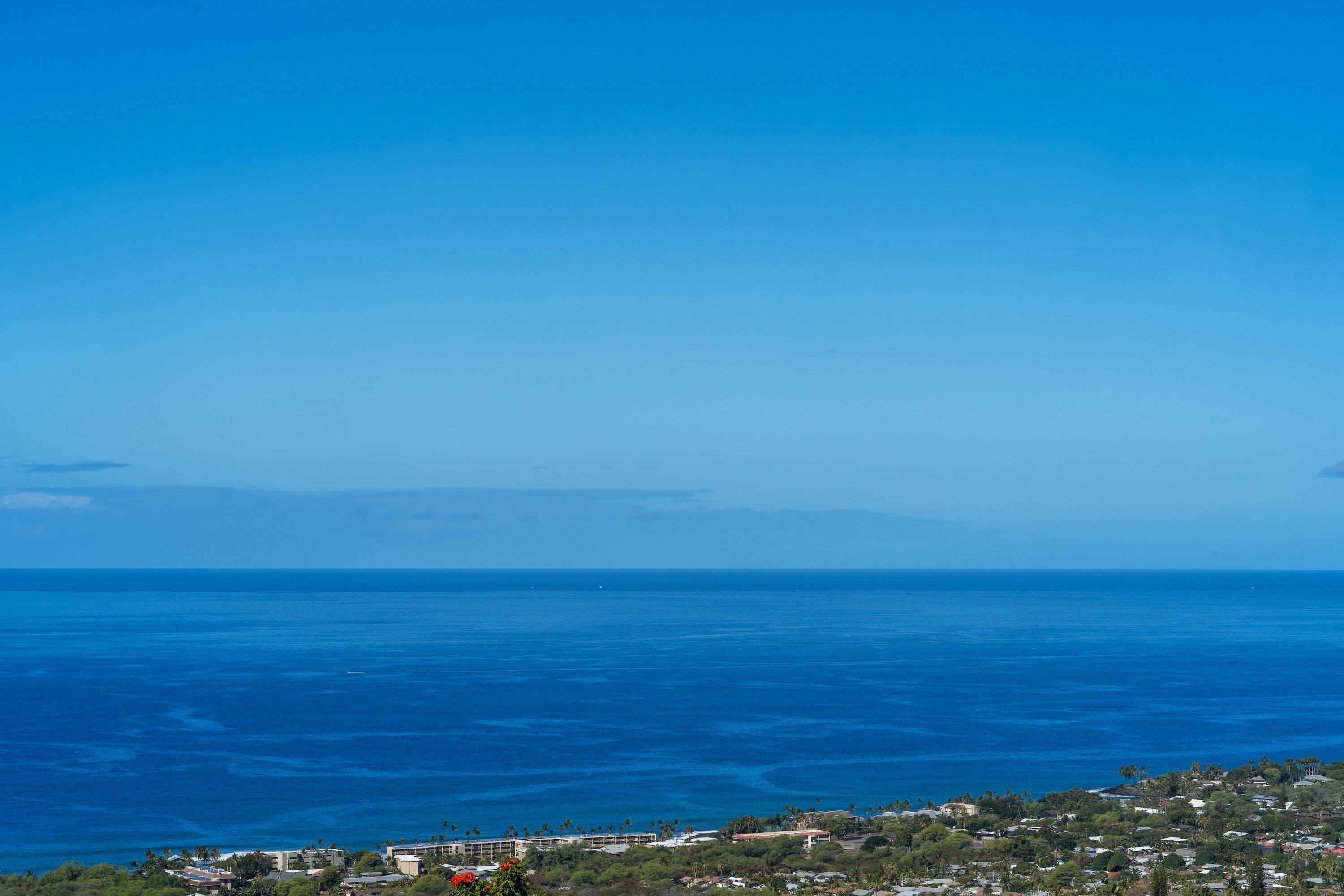 Blick auf die Küste mit Gebäuden und wolkenlosem, blauem Himmel.