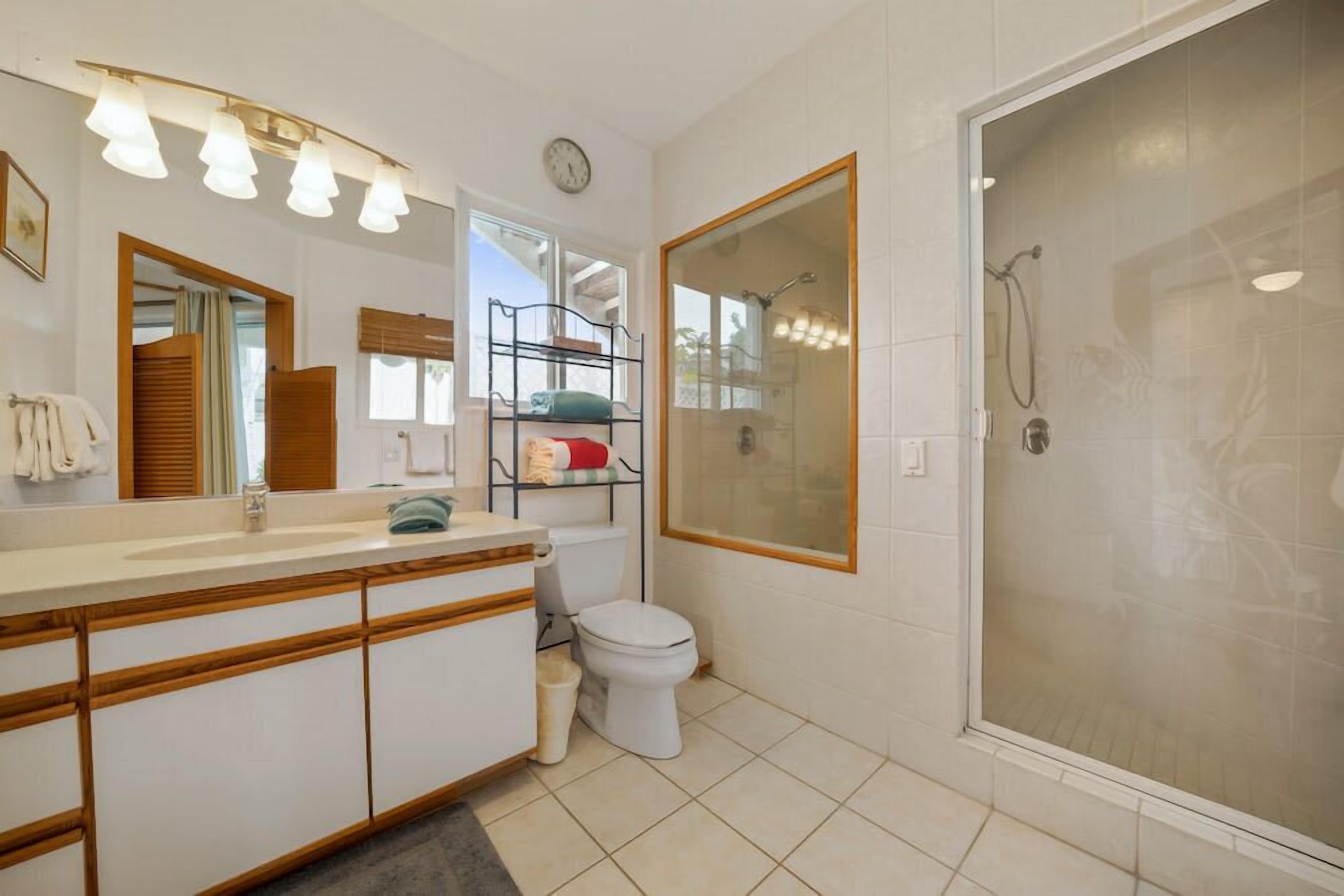 A modern bathroom with a shower, toilet, and vanity.