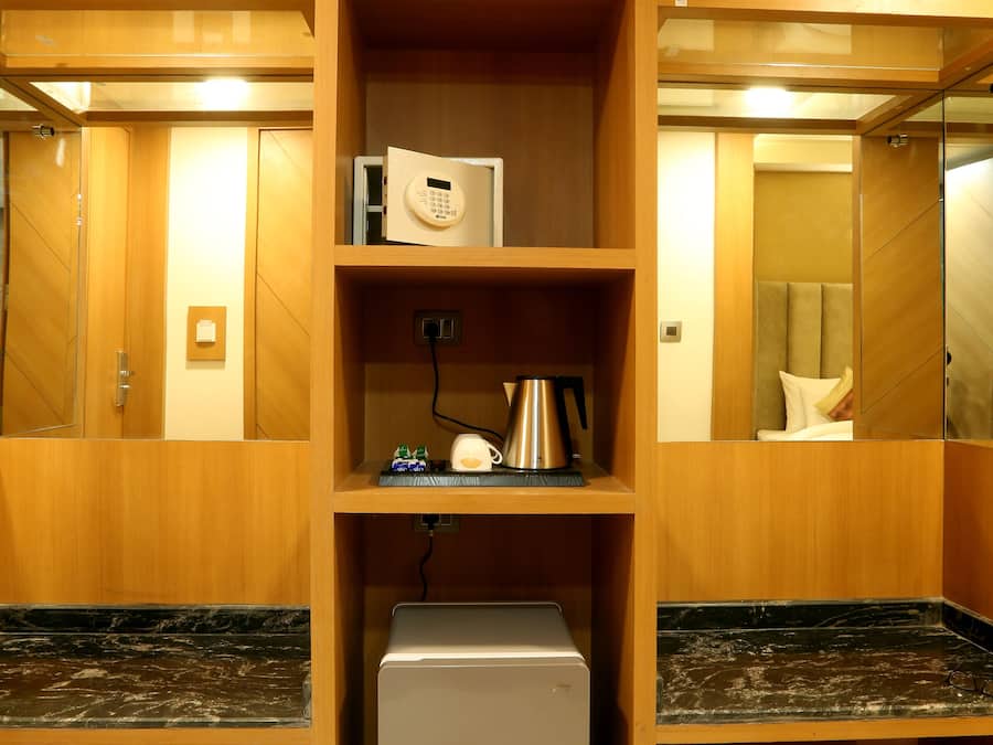 Een hotelkamer met houten planken, een magnetron, een waterkoker en een kleine koelkast.
