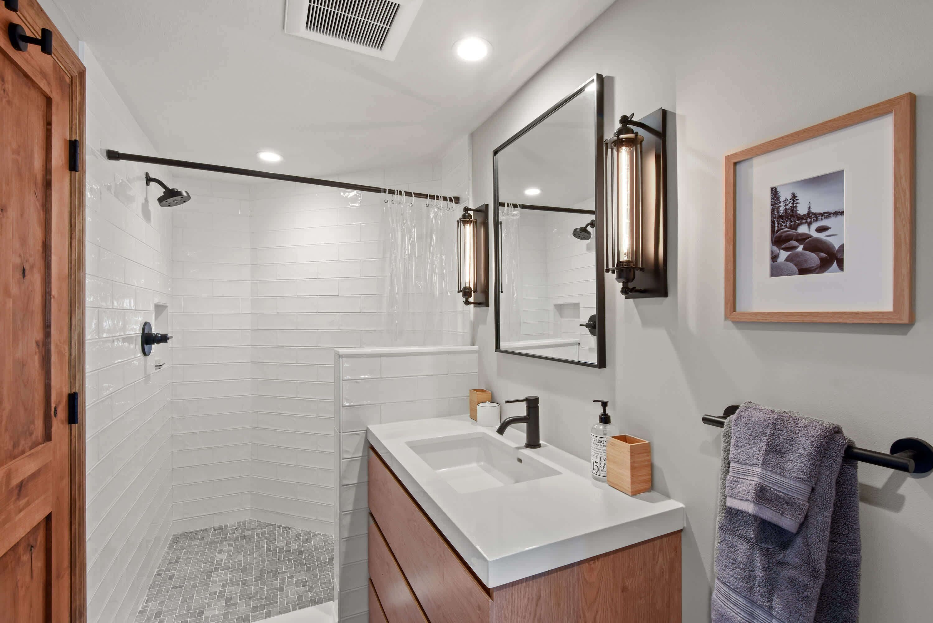 Un baño moderno con ducha, lavamanos y tocador.
