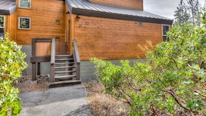 A two-story wooden cabin with a metal roof, a wooden staircase leading to a door, and a number '22' on the side. - Lake Forest Villa Patio w/ BBQ (Tahoe City)