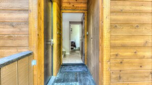 A wooden hallway with a door on the left and a bed in the background. - Lake Forest Villa Patio w/ BBQ (Tahoe City)
