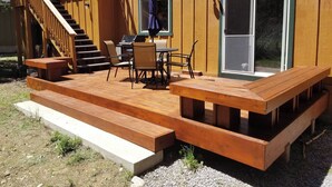 A wooden deck with outdoor seating and a staircase leading to a deck area. - Mckinney Estate w/ Roof Deck Beach & Hike! (Tahoma)