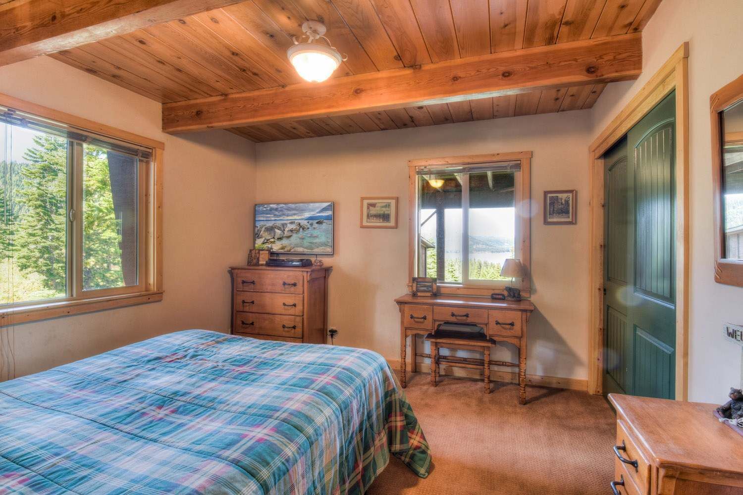 Une chambre à coucher avec un lit, une commode, un bureau et un miroir.