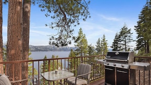 An outdoor deck with a grill, seating area, and a view of a lake and mountains. - Stunning Views at Stargazer Lakefront Studio! (Incline Village)