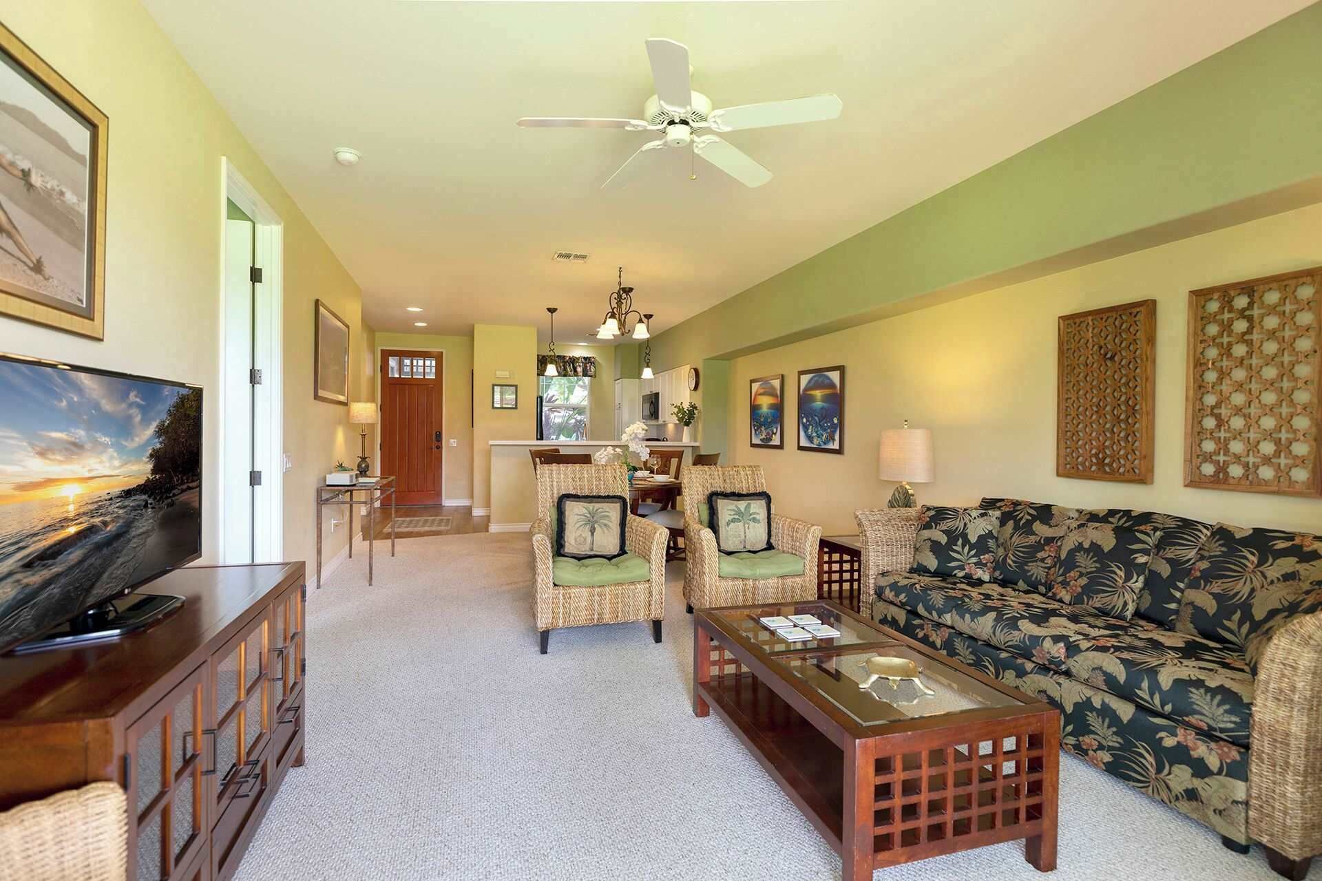 A spacious living area with a sofa, chairs, a coffee table, and a television.