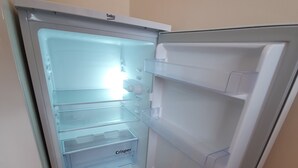 An open refrigerator with multiple shelves and a freezer compartment. - Beautiful Clean Double Room (Harrow)