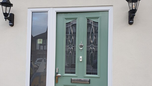 A green door with a white frame, a small window, and two wall-mounted lanterns. - Beautiful Clean Double Room (Harrow)