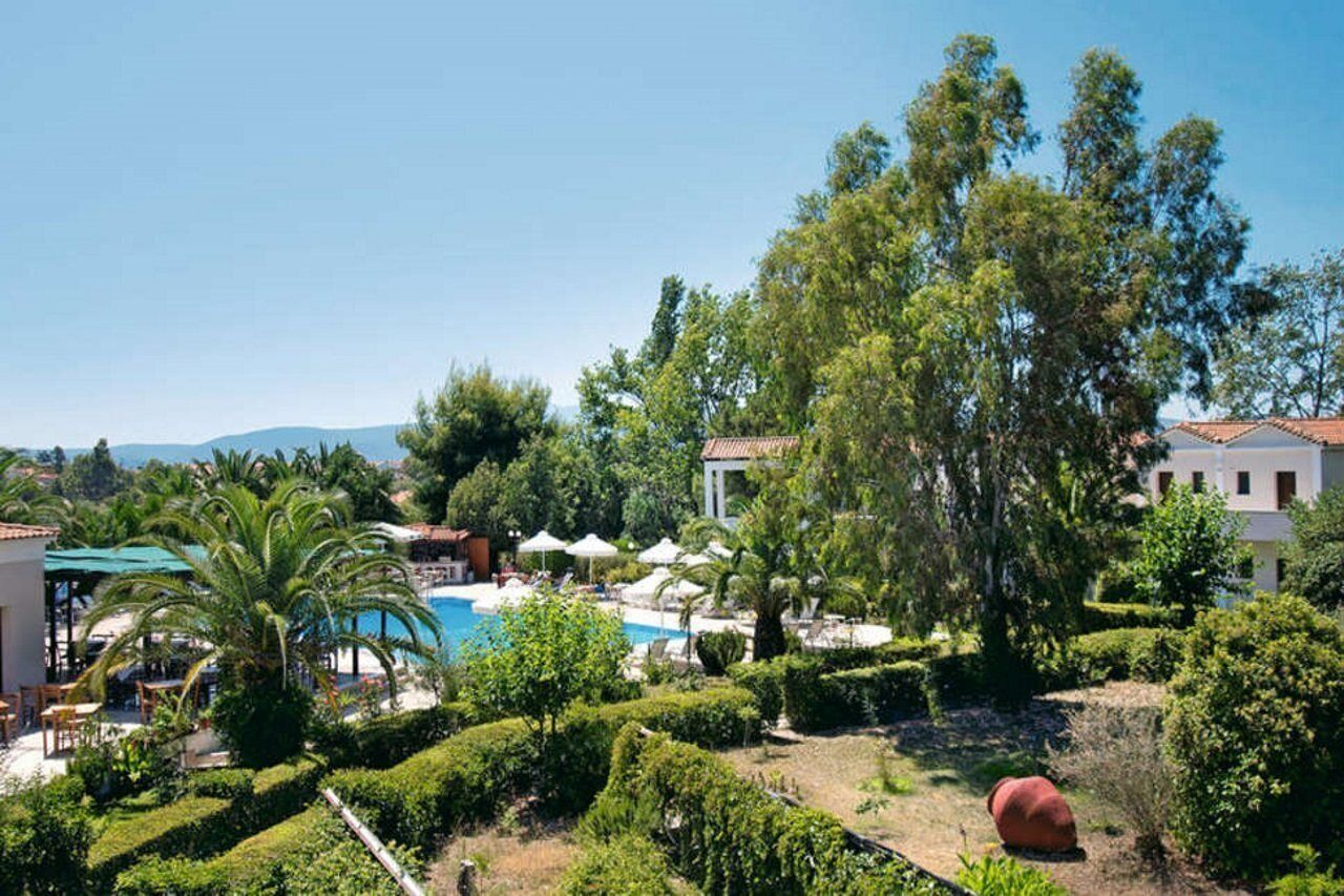 A resort with a pool, outdoor seating, and lush greenery.