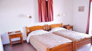 A double bed with a wooden frame, two bedside tables, and a wall-mounted curtain. - Elena Mare (Lesvos)