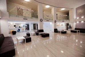 A spacious lobby with a high ceiling, multiple seating areas, and a reception desk. - Arena Mar Hotel & SPA - All Inclusive (Varna)