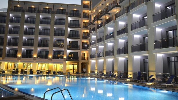 A multi-story hotel with a swimming pool, balconies, and a well-lit facade. - Arena Mar Hotel & SPA - All Inclusive (Varna)