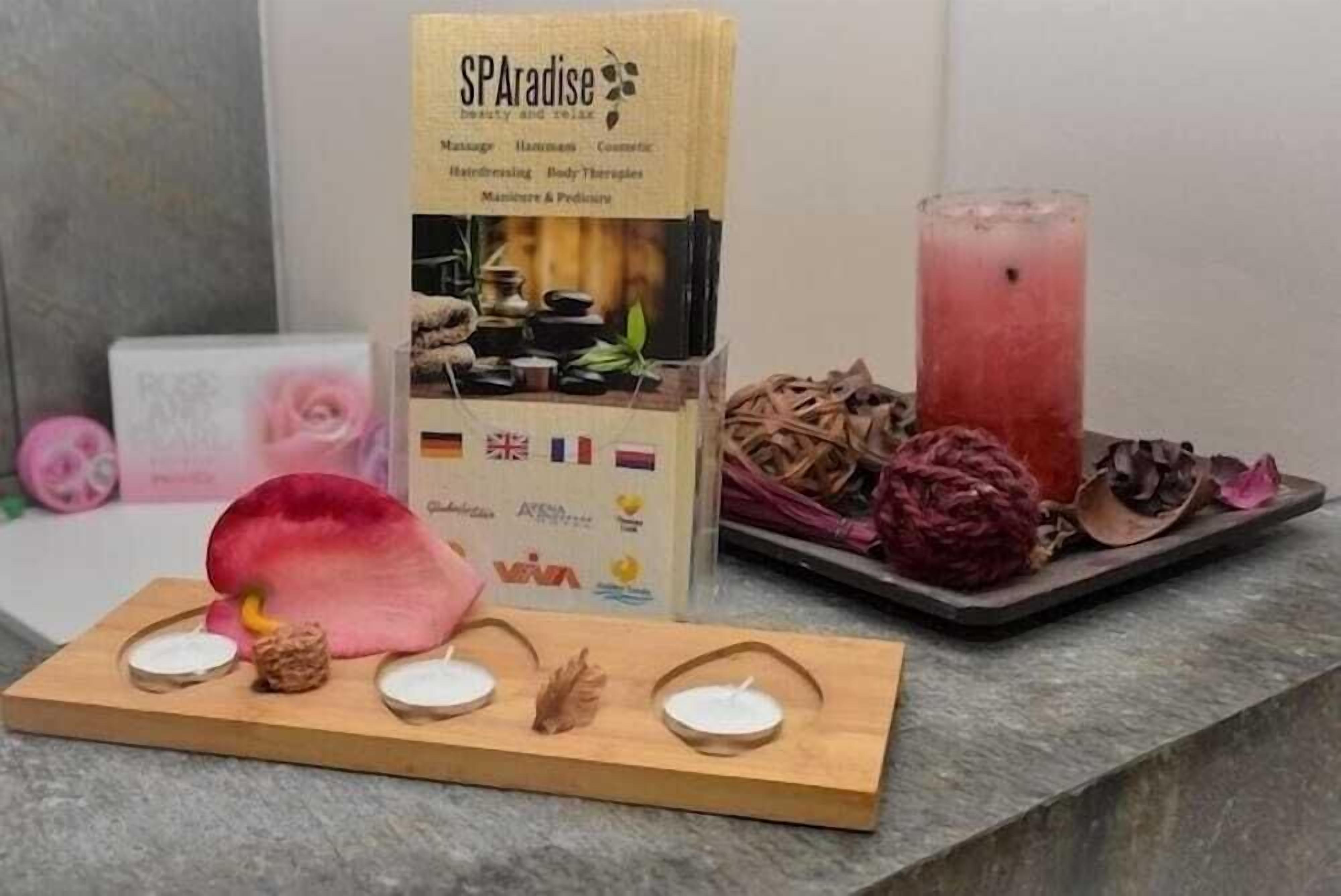 A spa package with a wooden tray, candles, and dried flowers.