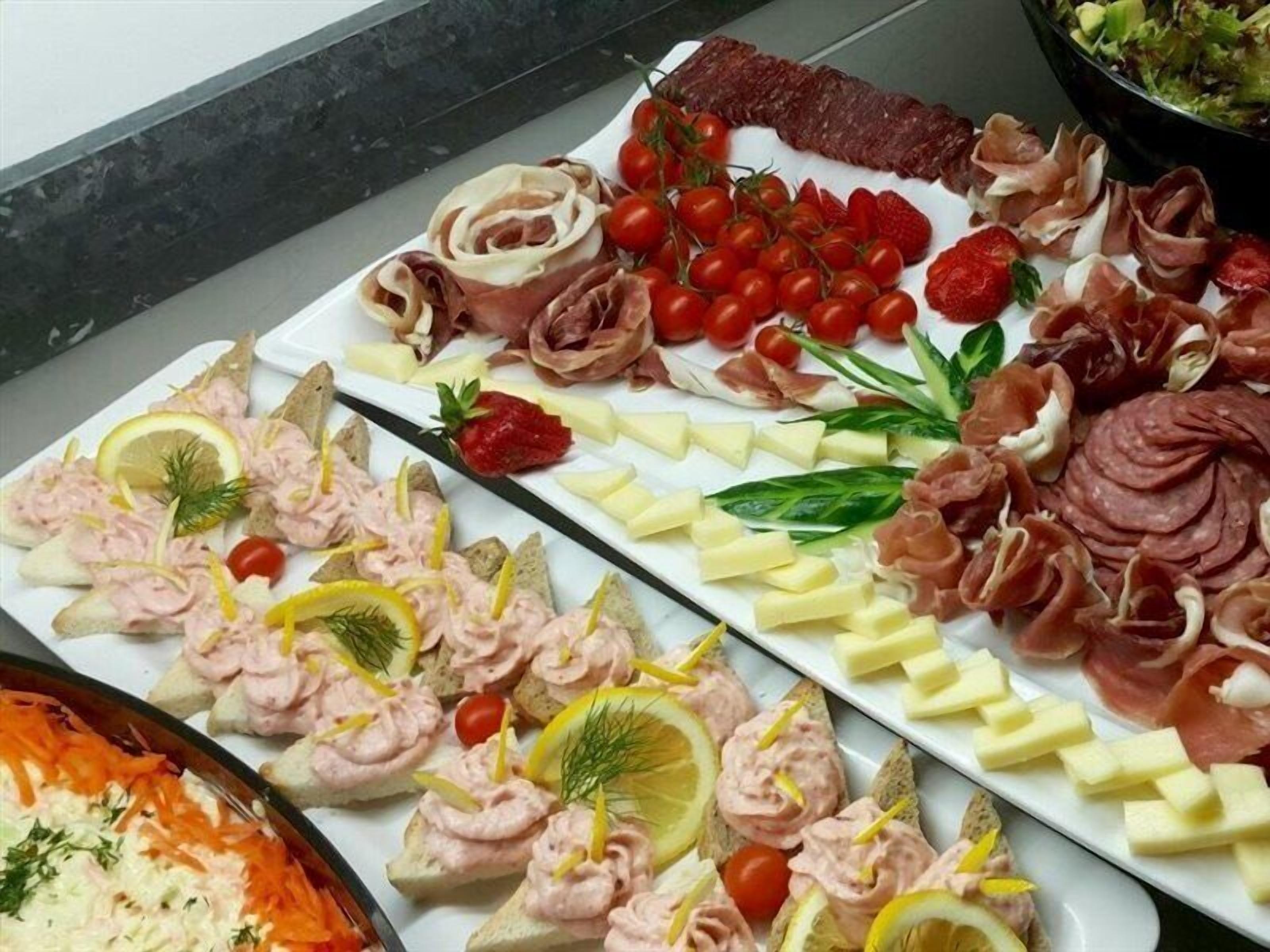 A buffet with various food items including meats, cheeses, and vegetables.