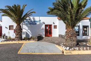 Un edificio blanco con puerta roja y un letrero que dice 'RESTAURANTE MIRADOR'.