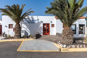 Un edificio bianco con una porta rossa e un cartello con su scritto 'RESTAURANTE MIRADOR'.