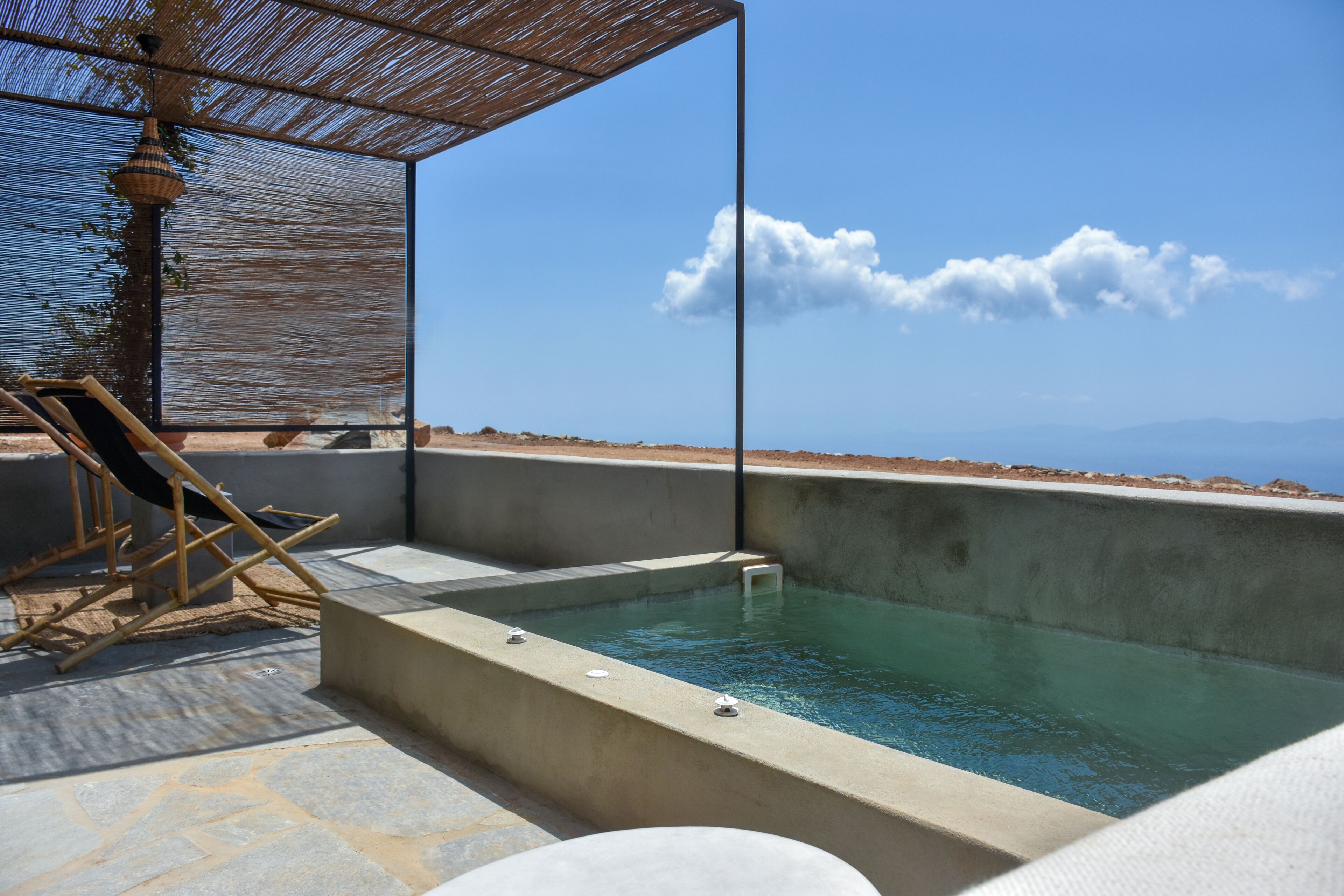 A hot tub with a clear view of the sea and mountains in the background.