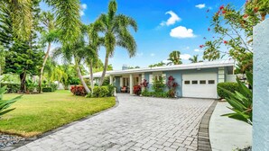 A modern two-story house with a paved driveway leading to a garage. - Private Heated Pool, walk to St Armand's! Perfect for families! (Lido Key)
