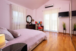 A bedroom with a bed, a dresser, a chair, a TV, and a mirror. - Luxury Villa Lovric Private Heated Pool (Omis)